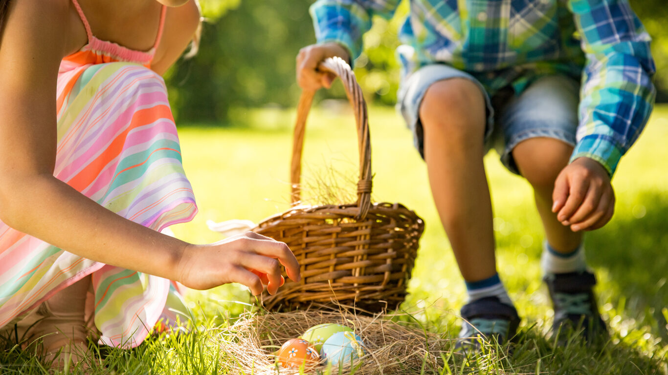 Cute boy and girl celebrating Easter, searching and eating choco