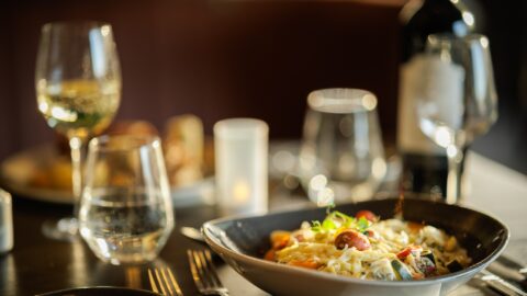 Enjoy a gourmet pasta dish with wine and candlelight in our elegant hotel restaurant for a memorable dining experience.