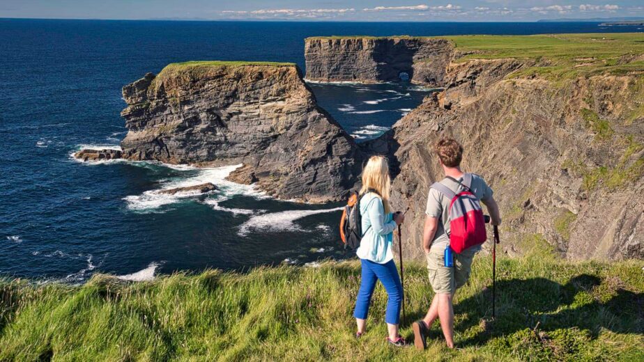 Visitors hike along stunning cliffside trails with panoramic ocean views, enjoying the lush landscape and fresh sea air.