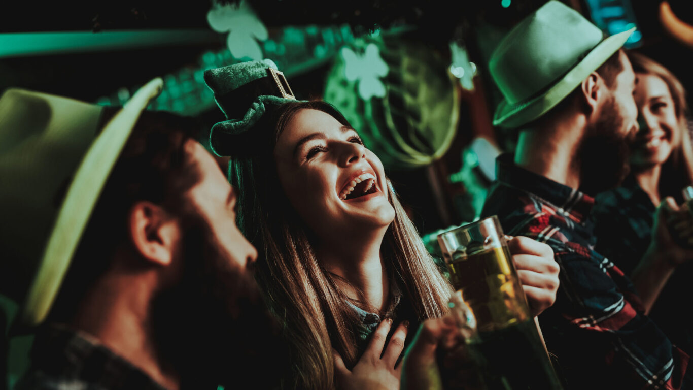 Guests enjoying a lively St. Patrick's Day celebration at the hotel bar, with festive decorations and cheerful atmosphere.