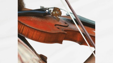 Close-up of a person playing a violin with text promoting live music every Saturday night in a hotel bar.