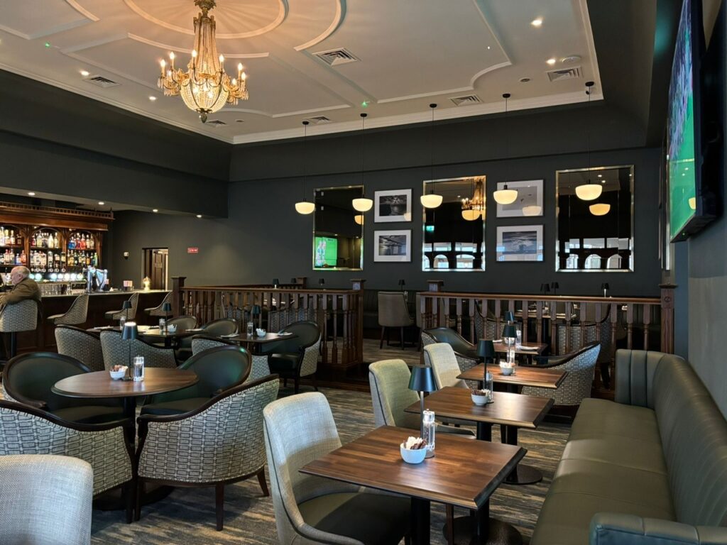 Elegant hotel bar with cosy seating, chandeliers, and modern decor, perfect for relaxing with a drink.