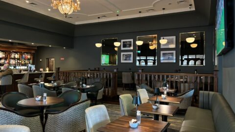 Elegant hotel bar with cosy seating, chandeliers, and modern decor, perfect for relaxing with a drink.