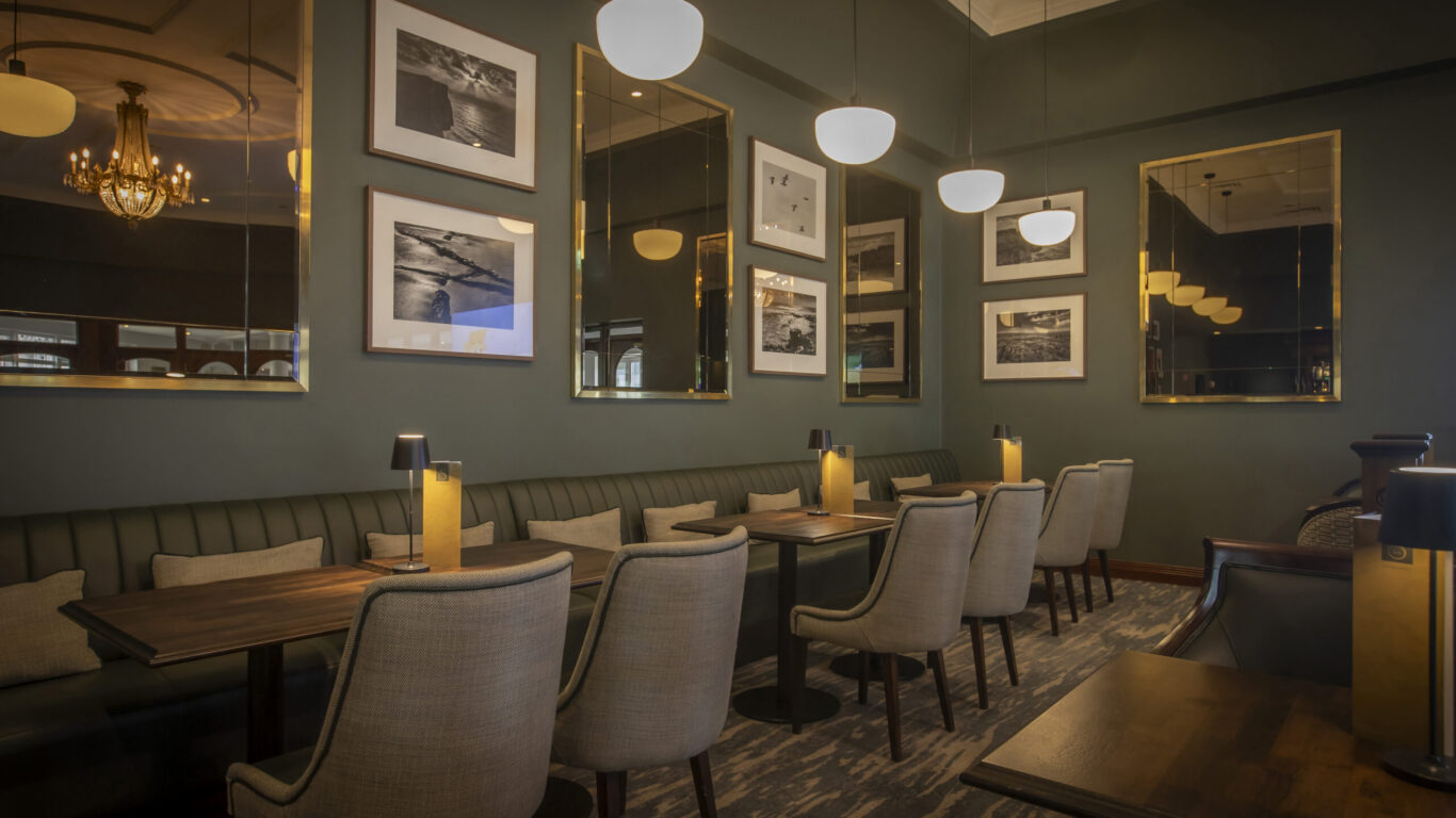 Elegant hotel dining area with modern seating, ambient lighting, artistic wall decor, inviting for a relaxing meal experience.