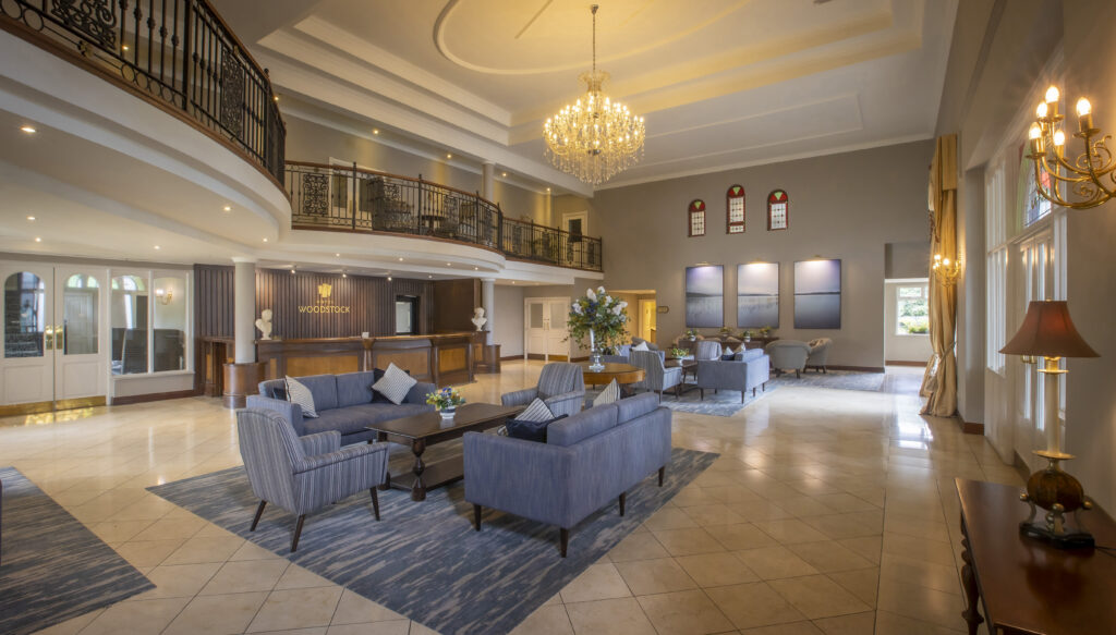 Elegant hotel lobby with plush sofas, grand chandelier, and a welcoming reception desk, exuding luxury and comfort.